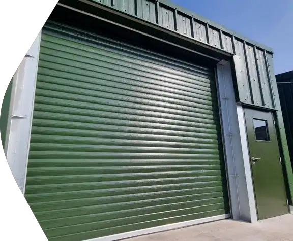 Green Priory roller shutter door on warehouse steel building